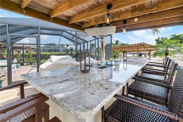 wooden deck featuring a bar, a lanai, and a grill