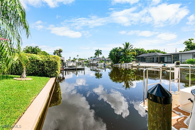 view of dock with a water view and a lawn