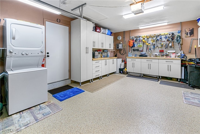 garage with a workshop area, stacked washing maching and dryer, and a garage door opener