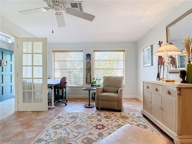 living area with light tile patterned floors and ceiling fan