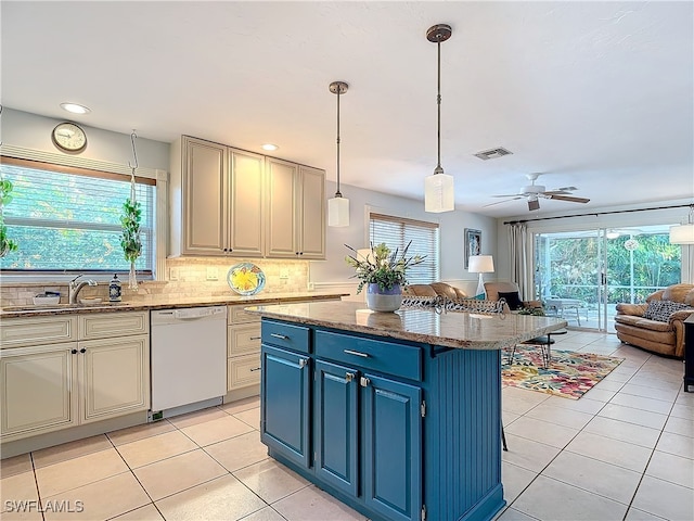 kitchen featuring a wealth of natural light, a center island, white dishwasher, and dark stone counters