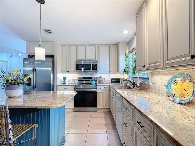 kitchen featuring light stone countertops, light tile patterned floors, hanging light fixtures, and appliances with stainless steel finishes