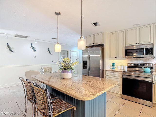 kitchen featuring a breakfast bar, a center island, hanging light fixtures, and appliances with stainless steel finishes