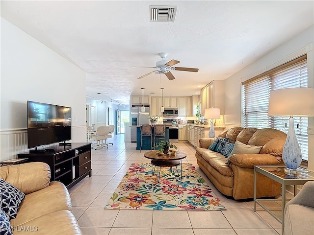 living room featuring light tile patterned floors, a textured ceiling, a wealth of natural light, and ceiling fan