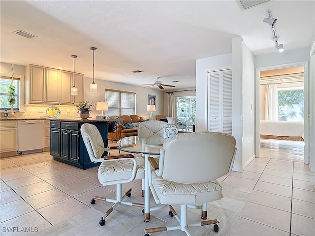 tiled dining space with track lighting, plenty of natural light, and ceiling fan