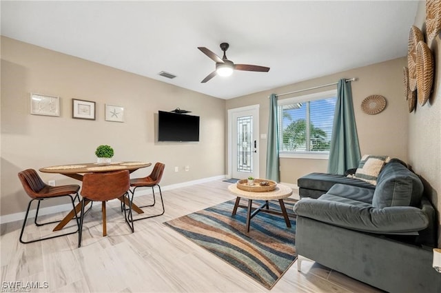 living room with ceiling fan and light hardwood / wood-style flooring