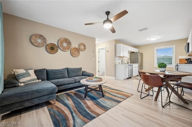 living room featuring ceiling fan and light hardwood / wood-style floors