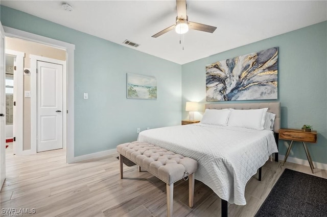 bedroom with light wood-style floors, baseboards, visible vents, and a ceiling fan