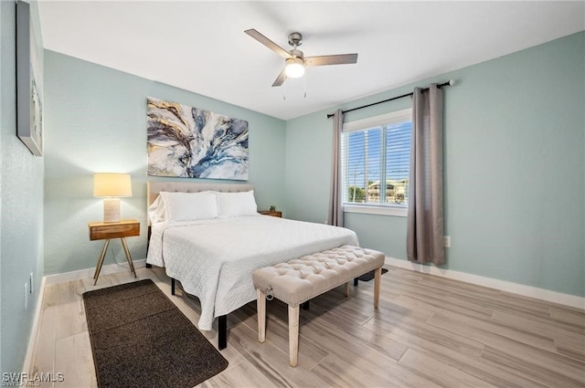 bedroom featuring light wood-style floors, baseboards, and a ceiling fan