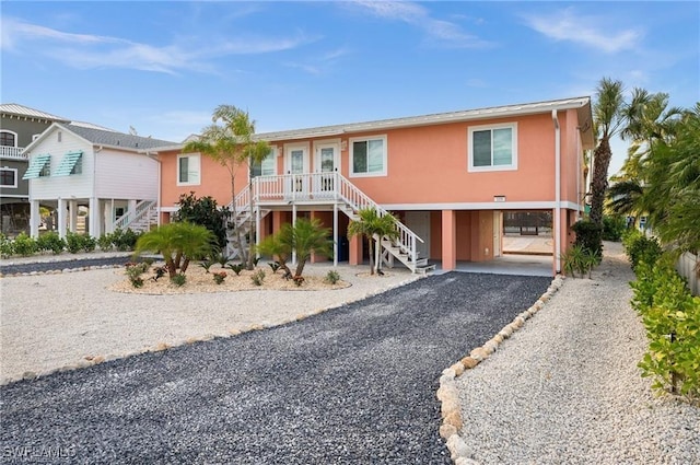 113/115 Bahia Viaduct, Fort Myers Beach, FL 33931 - beach home featuring a carport, stairway, driveway, and stucco siding