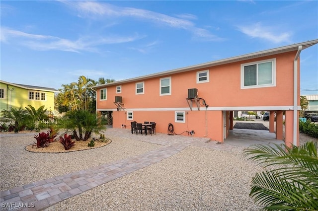 back of property with central AC and a patio area