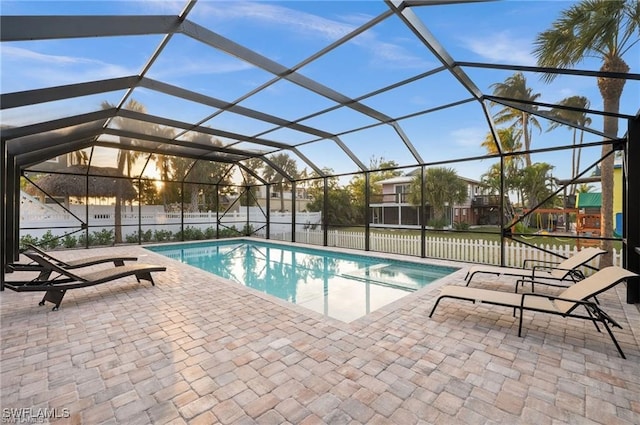 view of swimming pool with glass enclosure, a patio, fence, and a fenced in pool