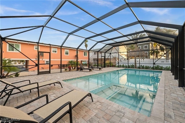 outdoor pool with a patio area and glass enclosure