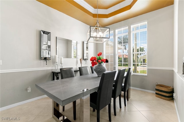 tiled dining room with plenty of natural light, ornamental molding, a tray ceiling, and a chandelier