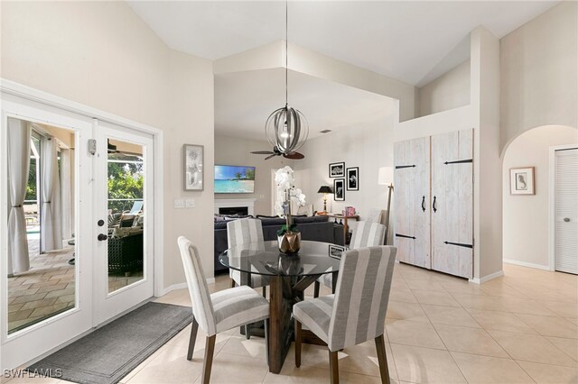 tiled dining room with a chandelier and high vaulted ceiling