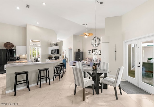 tiled dining room with french doors, high vaulted ceiling, and ceiling fan