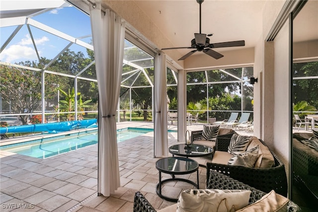 view of pool with glass enclosure, ceiling fan, and a patio