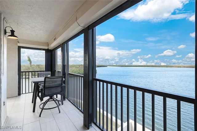 sunroom / solarium featuring a water view