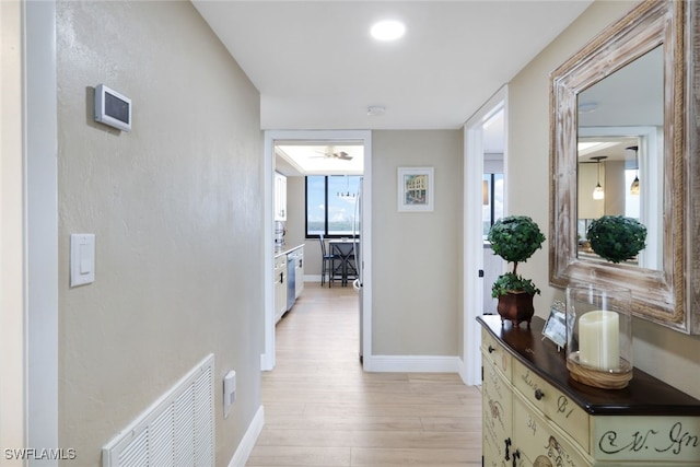 hallway with light hardwood / wood-style floors and plenty of natural light