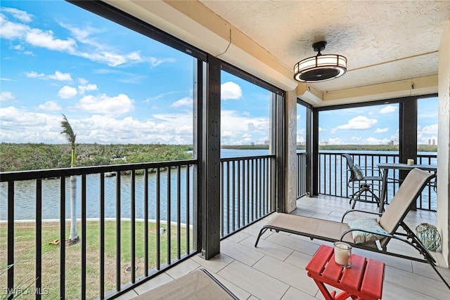 sunroom featuring a water view