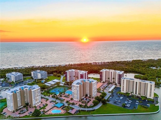 aerial view at dusk featuring a water view