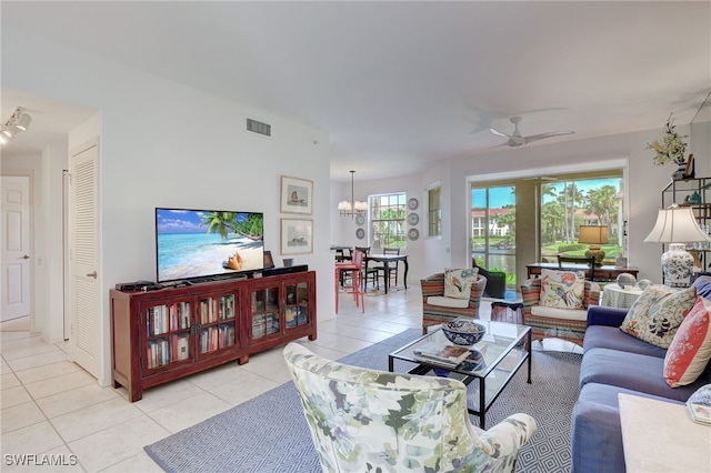 living room featuring ceiling fan with notable chandelier and light tile patterned flooring