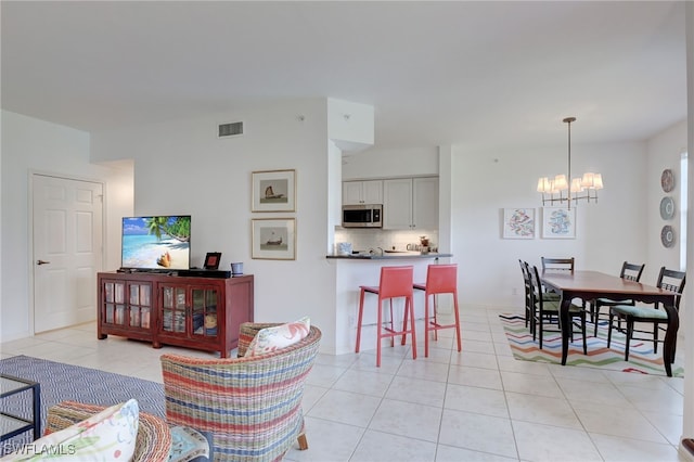 living room featuring light tile patterned floors and an inviting chandelier