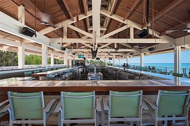 interior space with vaulted ceiling with beams, a water view, and wood ceiling