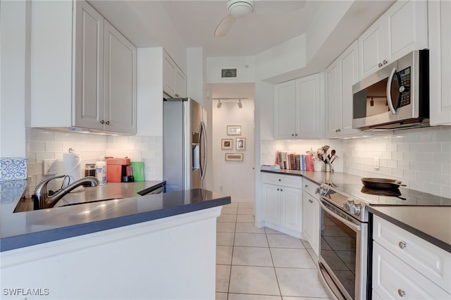 kitchen with white cabinets, sink, light tile patterned floors, tasteful backsplash, and stainless steel appliances