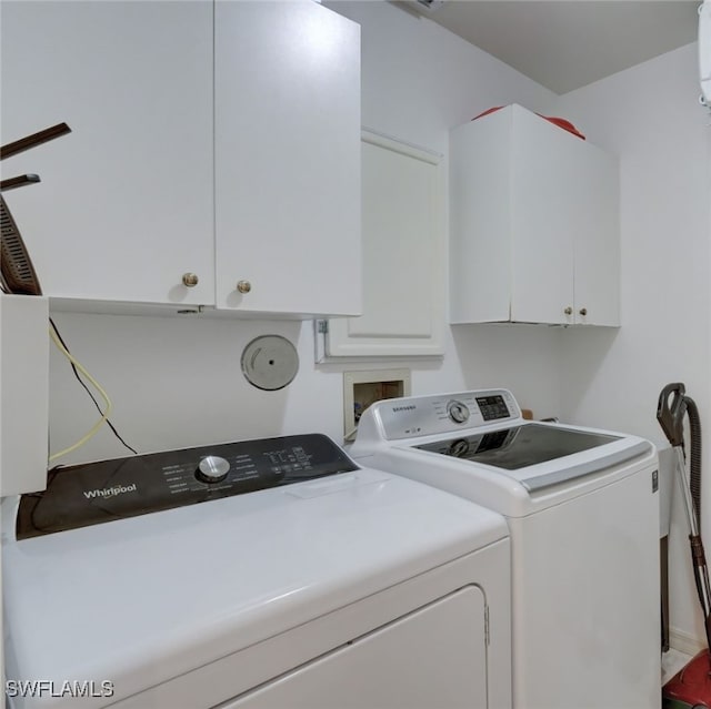 laundry room with cabinets and washer and clothes dryer