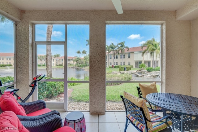 sunroom featuring a water view