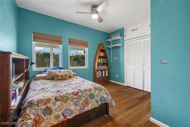 bedroom featuring ceiling fan, dark wood-type flooring, and a closet