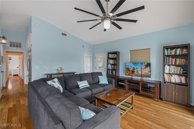 living room featuring ceiling fan, light hardwood / wood-style floors, and high vaulted ceiling