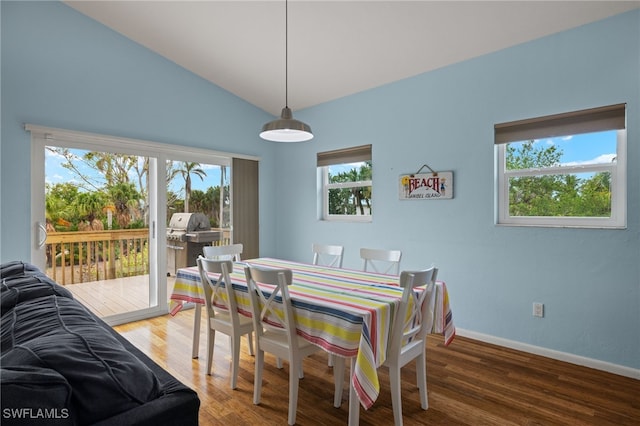 dining room featuring dark wood-type flooring and vaulted ceiling