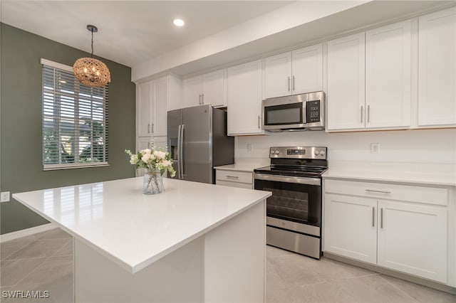 kitchen with a center island, white cabinetry, stainless steel appliances, and hanging light fixtures