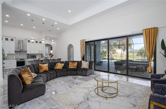 living room featuring a high ceiling and ornamental molding