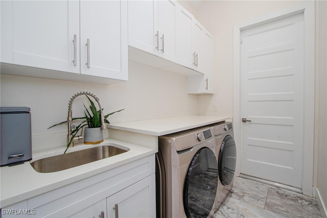 laundry room featuring cabinets, separate washer and dryer, and sink