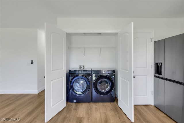 laundry room with light wood-type flooring and washer and clothes dryer