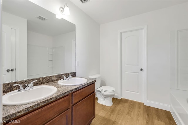 bathroom with toilet, vanity, and hardwood / wood-style flooring