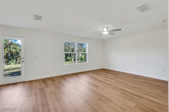 spare room featuring ceiling fan, a healthy amount of sunlight, and light hardwood / wood-style flooring