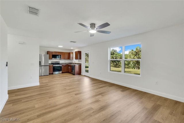 unfurnished living room featuring light hardwood / wood-style floors, ceiling fan, and sink