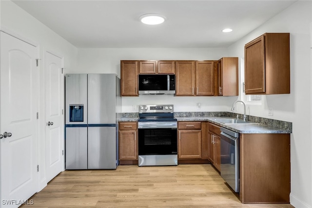 kitchen with sink, stainless steel appliances, and light hardwood / wood-style flooring