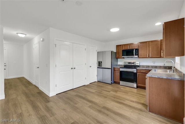 kitchen featuring appliances with stainless steel finishes, light wood-type flooring, and sink