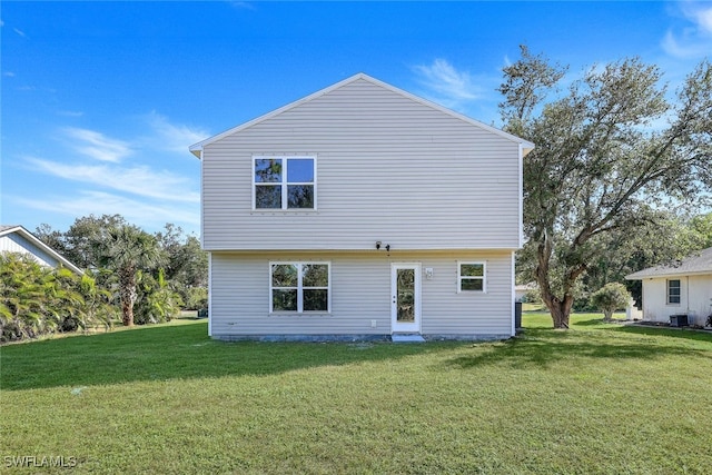 rear view of house featuring a lawn and cooling unit