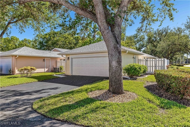 single story home with a front lawn, cooling unit, and a garage