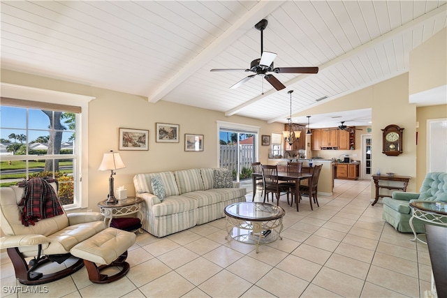 living room with ceiling fan, vaulted ceiling with beams, a wealth of natural light, and light tile patterned flooring