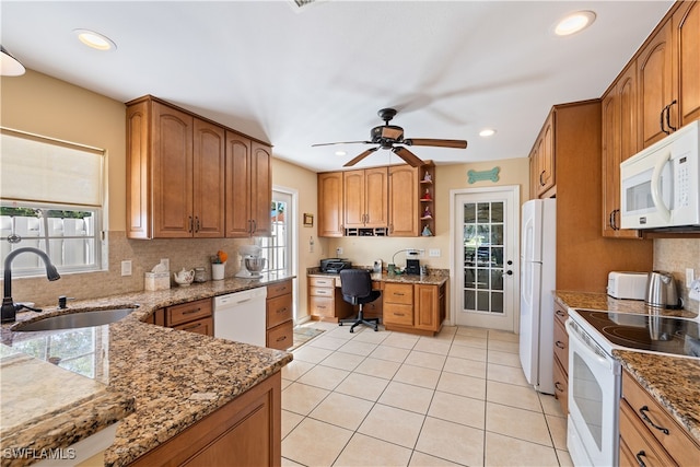 kitchen featuring sink, light stone counters, white appliances, decorative backsplash, and light tile patterned floors