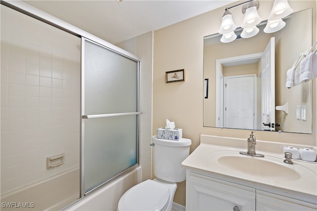 full bathroom featuring vanity, combined bath / shower with glass door, and toilet