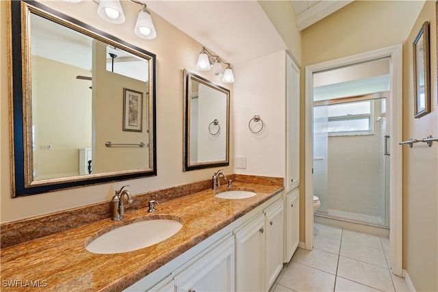 bathroom with tile patterned flooring, vanity, toilet, and an enclosed shower