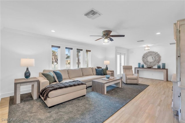 living room featuring ceiling fan, light hardwood / wood-style floors, and a wealth of natural light